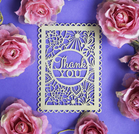 A gold coloured papercut thank you post card