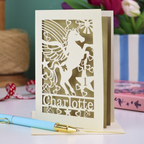 A laser cut keepsake 1st birthday card with cut out unicorn design, the age "1" cut out from inside a star shape, and personalised with the name "Charlotte"