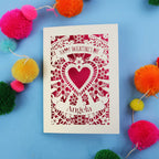 Handmade Luxury Valentine's Day card with decorative heart design on a blue background with colourful pom-poms.