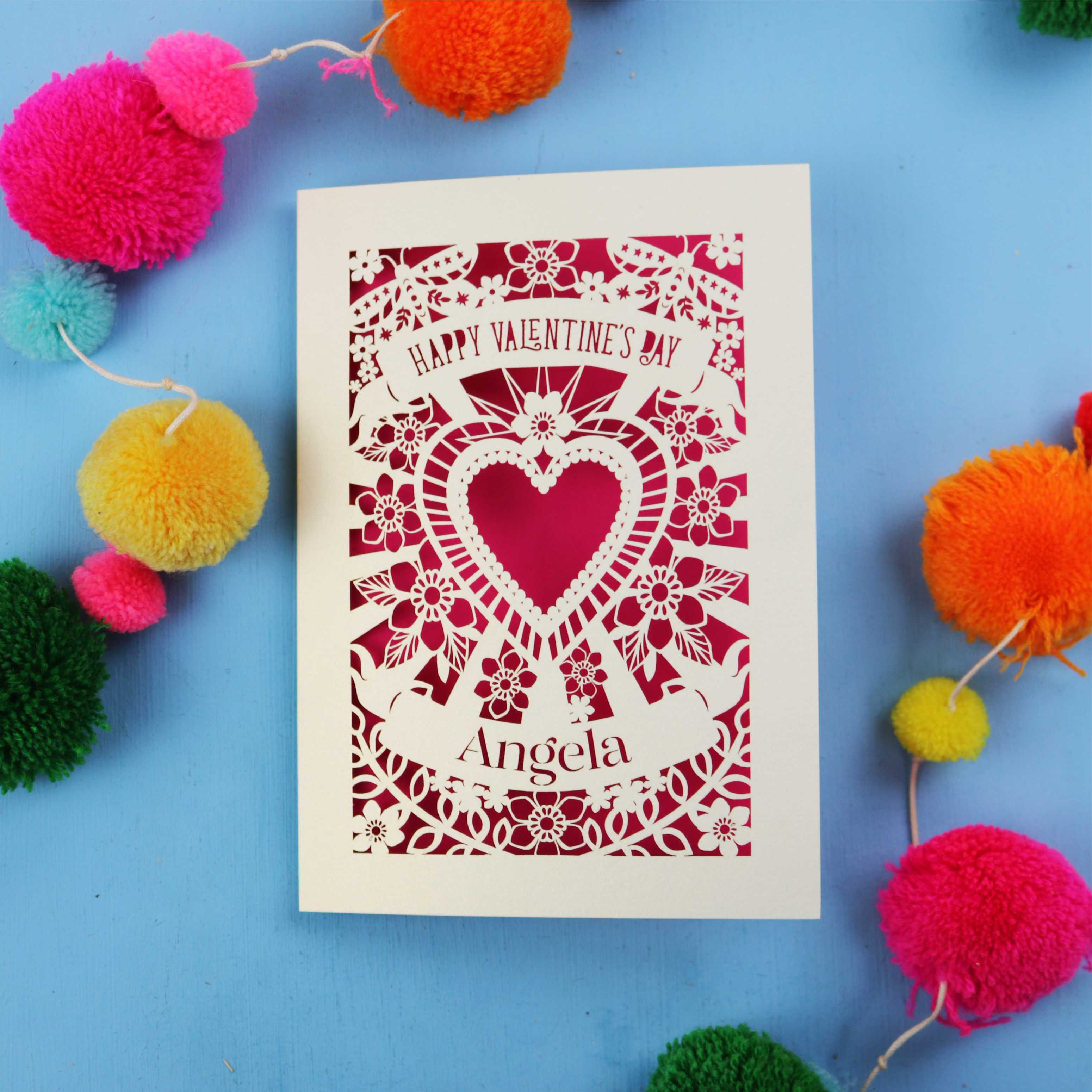 Handmade Luxury Valentine's Day card with decorative heart design on a blue background with colourful pom-poms.