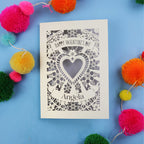 Luxury Valentine's Day card with decorative heart design on a blue background with colourful pom-poms.