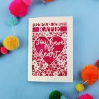Personalised Valentine's Card with 'Katie, you have my heart' text on a blue background with colourful pom-poms.