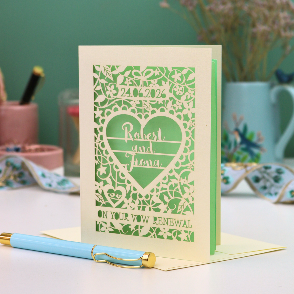 Card with decorative text and heart design on a table with stationery items.