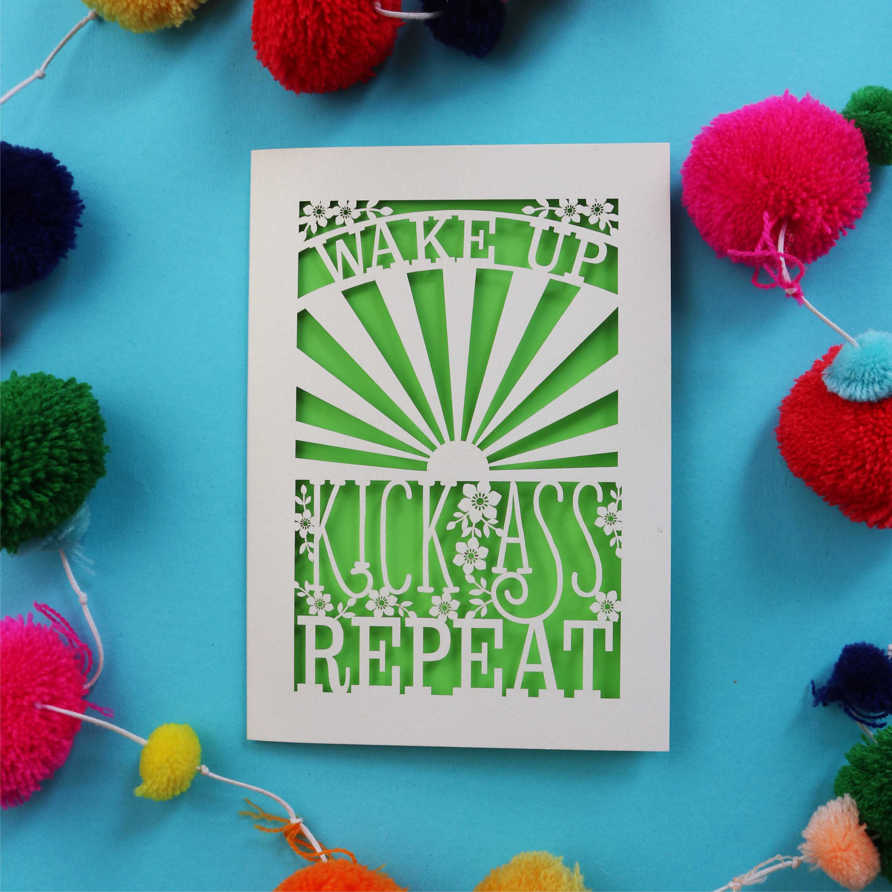 A laser cut motivational greetings card that says "Wake up, Kick ass, repeat"