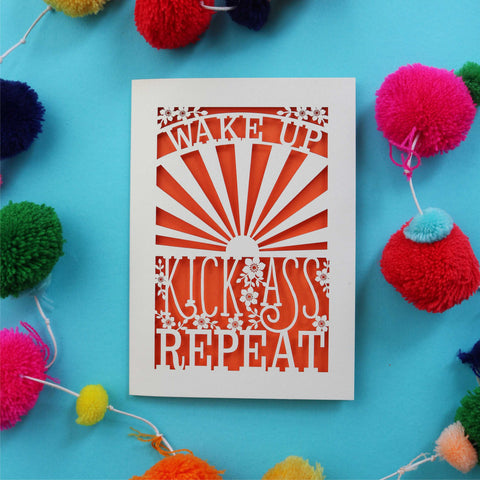 A laser cut motivational greetings card that says "Wake up, Kick ass, repeat"