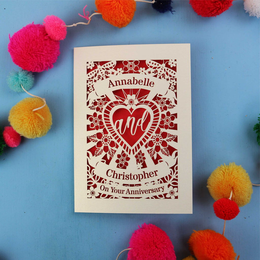 Personalised paper cut anniversary card with decorative elements on a blue background