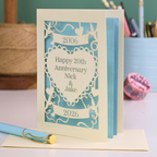20th anniversary card with decorative elements on a table with stationery items.