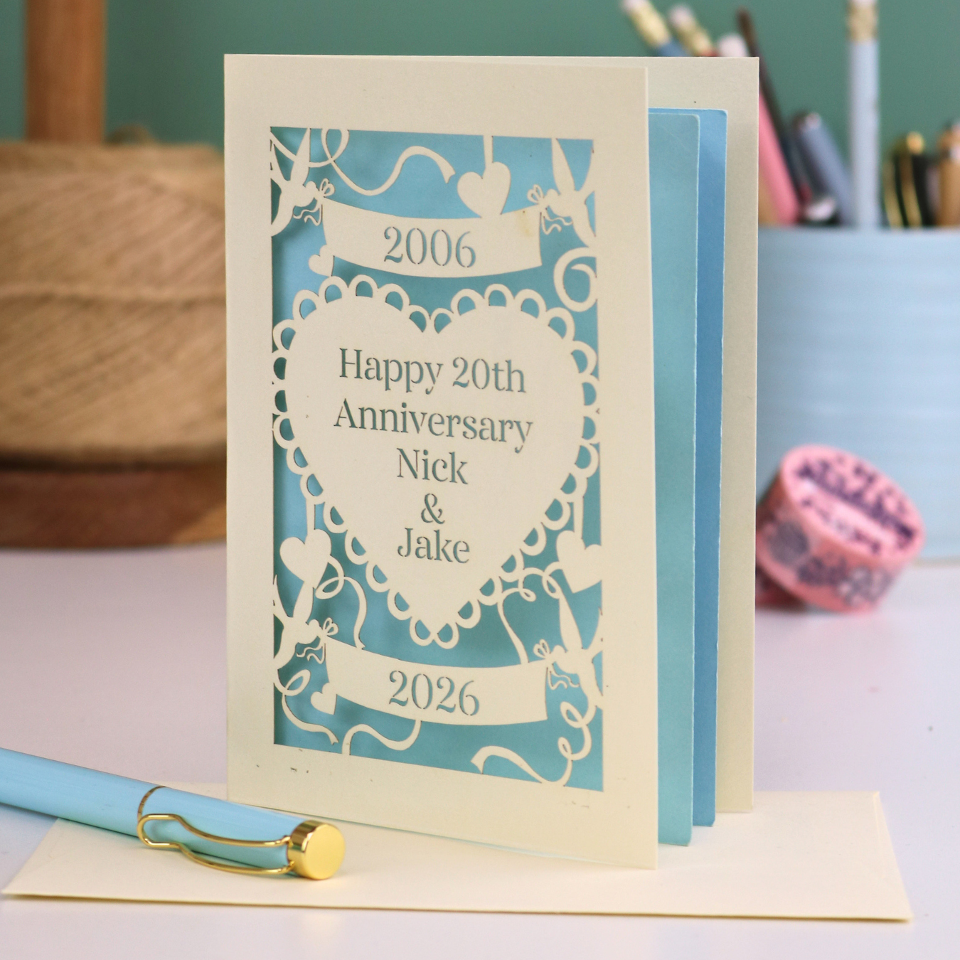 20th anniversary card with decorative elements on a table with stationery items.