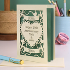 Personalized 20th anniversary card with decorative elements on a table.