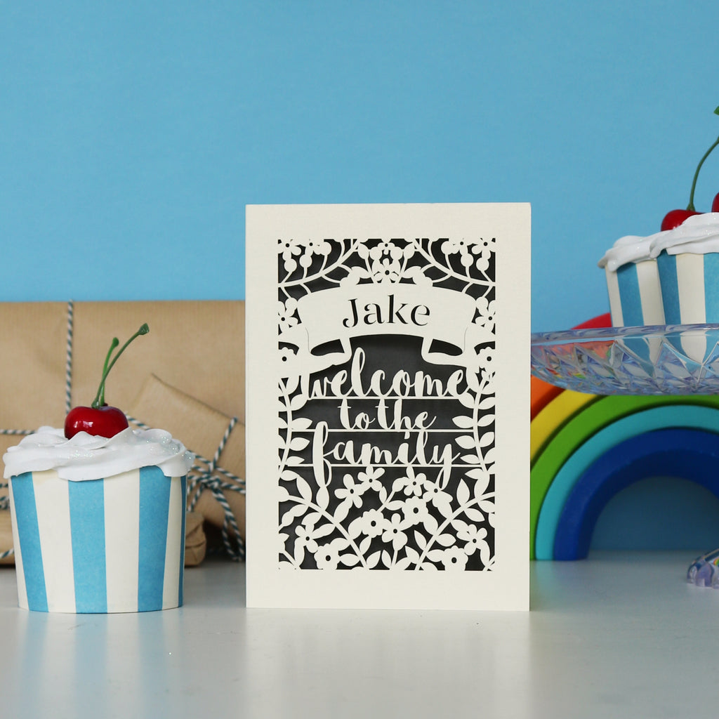 A laser cut card that says Welcome to the Family"