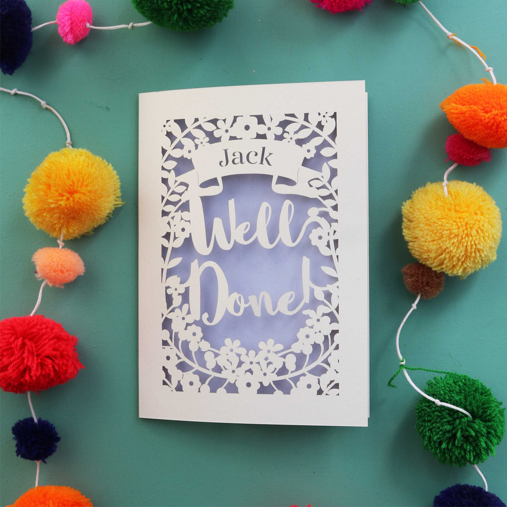 A paper cut card to send congratulations, made in the UK. Laser cut card is personalised with a name and says Well Done in a script font.