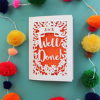 A personalised graduation card that says "Well Done" and has the recipient's name in a banner