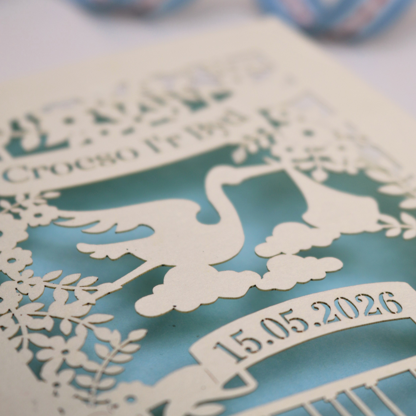Personalized laser-cut Welsh New Baby card with stork design and text: "Croeso I'r Byd" on cream card with light blue paper backing