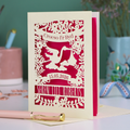 Personalized laser-cut Welsh New Baby card with stork design and text: "Croeso I'r Byd", personalised with the date of birth and baby's name, on a blurred background