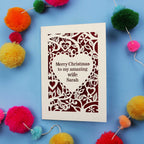 Christmas card with personalized message on a blue background with colourful pom-poms.