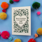 Christmas card with personalized message surrounded by colourful pom-poms on a blue background