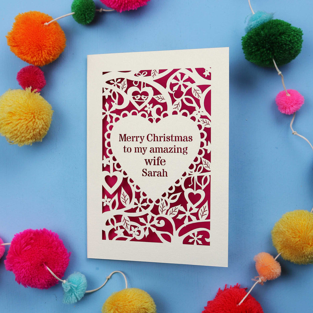 Wife Christmas card with personalized message on a blue background with colourful pom-poms.