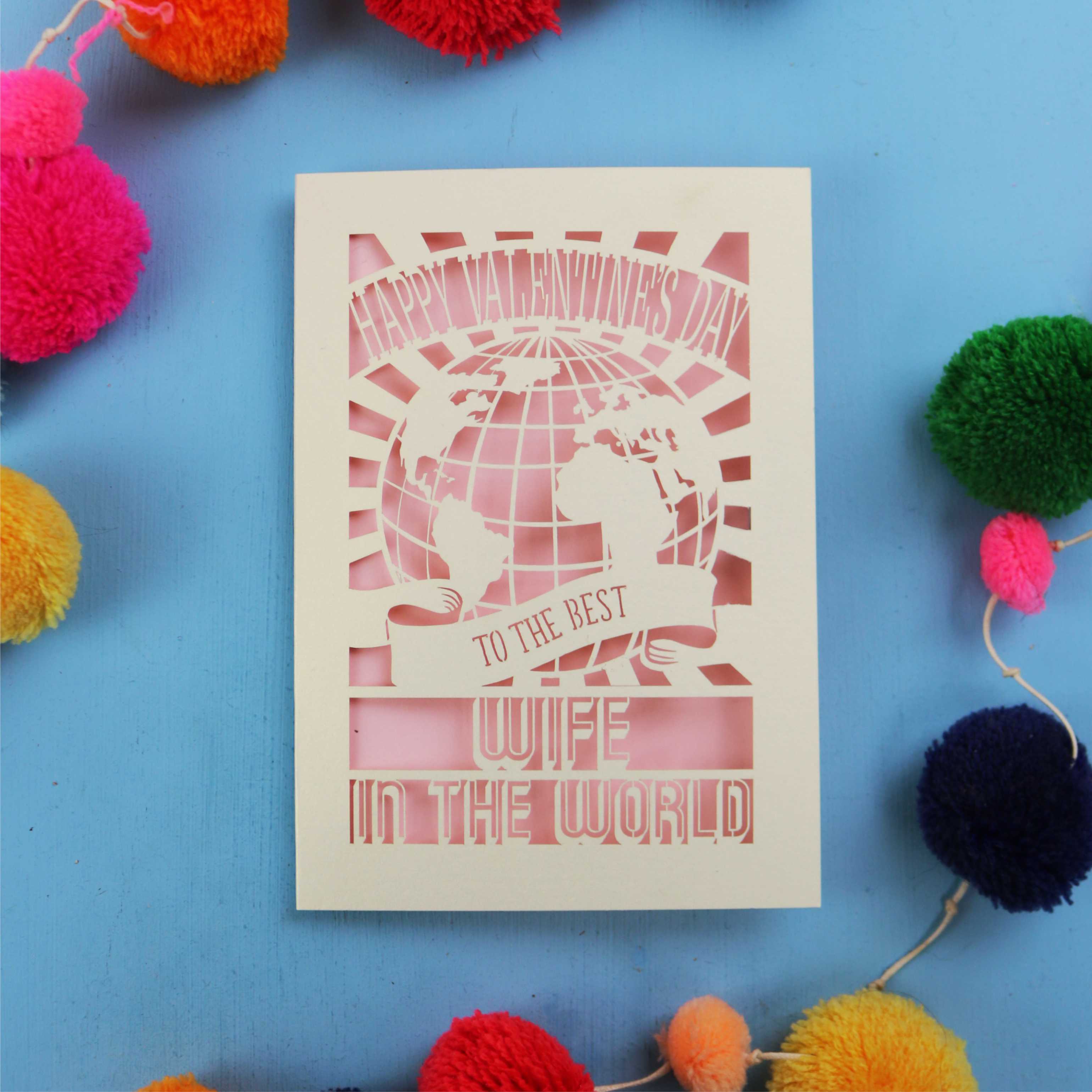 A laser cut Wife Valentine's Day card for the best wife in the world with colourful pom-poms on a blue background