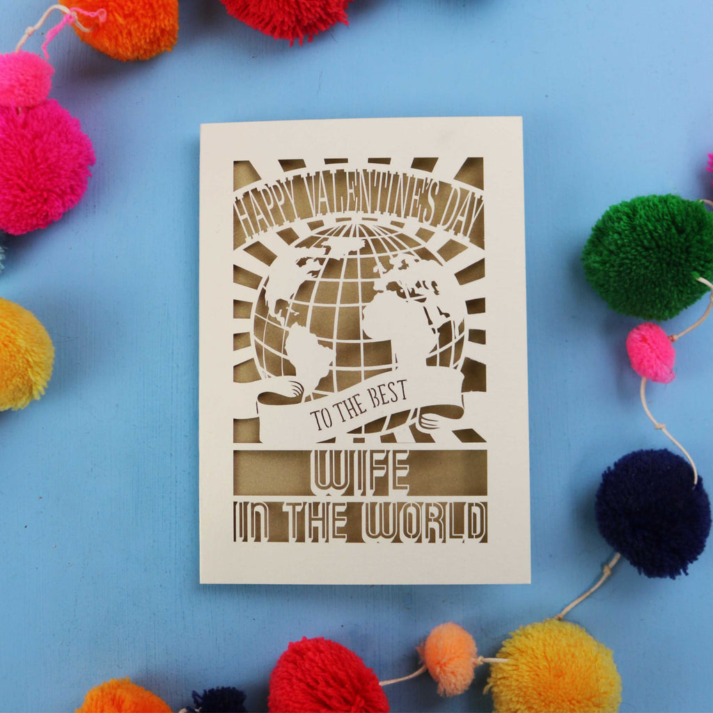 A cut out Wife Valentine's Day card for the best wife in the world with colourful pom-poms on a blue background