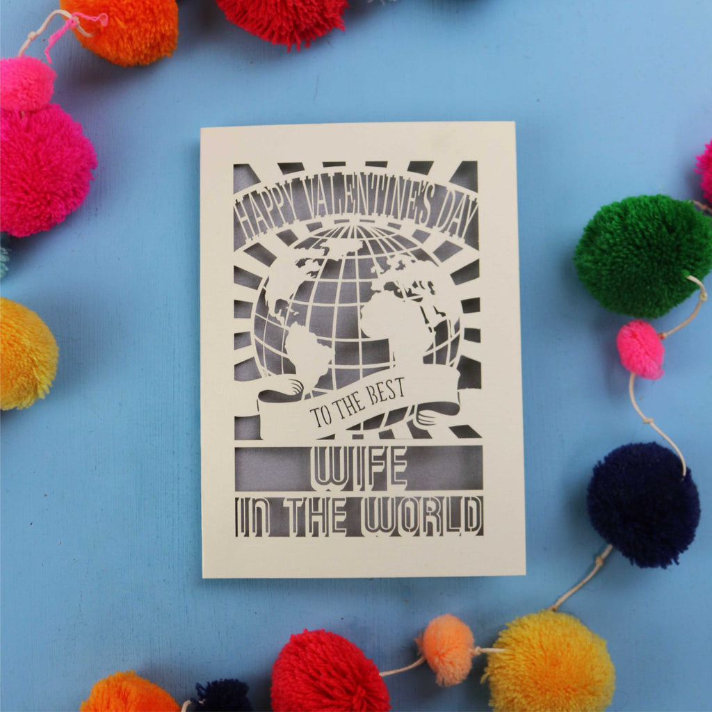 A paper cut Wife Valentine's Day card for the best wife in the world with colourful pom-poms on a blue background