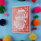 Decorative card with 'It's the most wonderful time of the year' text on a blue background with colourful pom-poms.