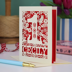 A laser cut 1st birthday card with decorative 1 and woodland design including owl, bunnies, squirrel and hedgehog, personalised with a name.