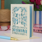 A laser cut 1st birthday card with decorative 1 and woodland design, personalised with a name.