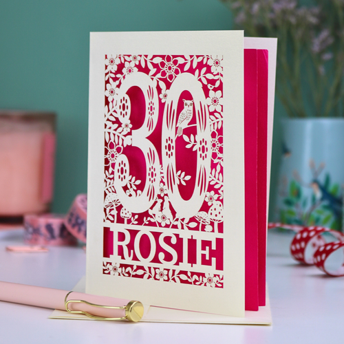 Personalised 30th birthday card with '30 Rosie' design on a table with stationery items.