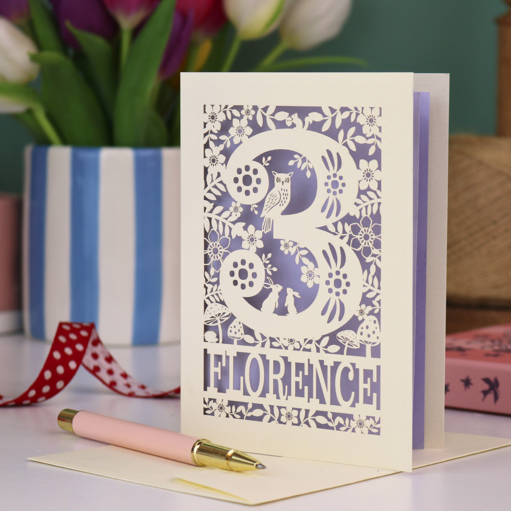 Decorative 3rd Birthday card with floral woodland and owl design, featuring the name 'Florence', on a table with a pen and flowers.