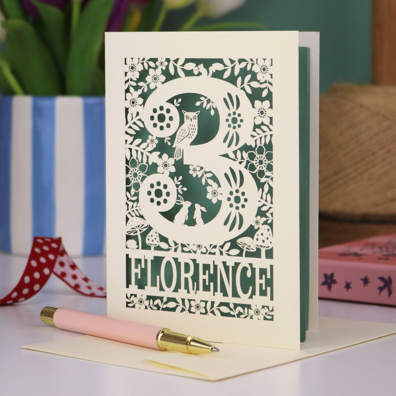 Decorative 3rd Birthday card with floral woodland and owl design, featuring the name 'Florence', on a table with a pen and flowers.