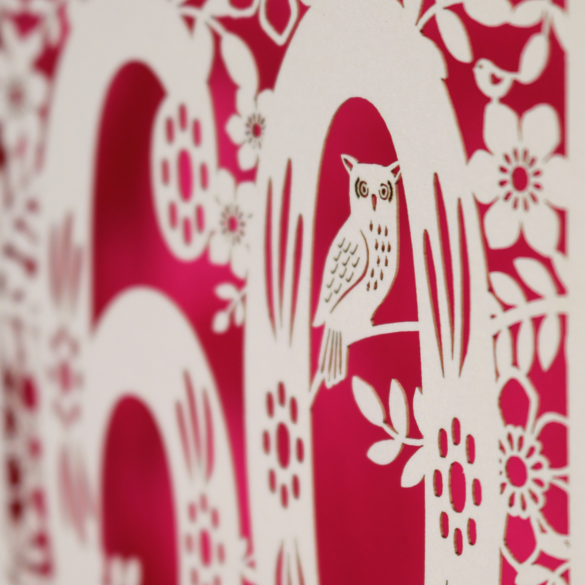 A close up detail of a laser cut 60th birthday card with tiny laser cut owl