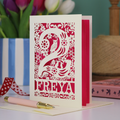 A laser cut 2nd birthday card with woodland design and decorative '2', personalised with a name. The card has tiny cut out woodland elements including bunnies, toadstools, squirrel and owl.