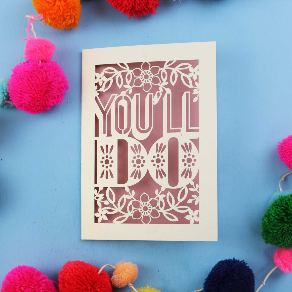 Cut out Valentines card with 'YOU'LL DO' text on a blue background with colourful pom-poms.