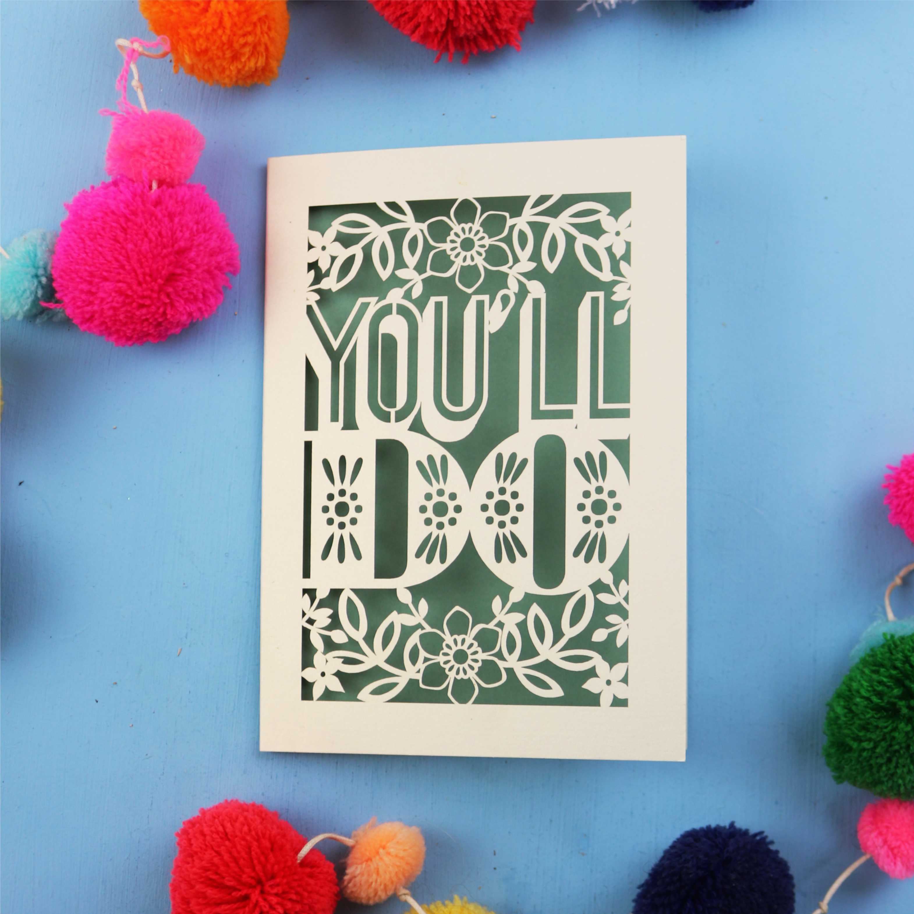 Cute Valentine's card with 'YOU'LL DO' text on a blue background with colourful pom-poms.