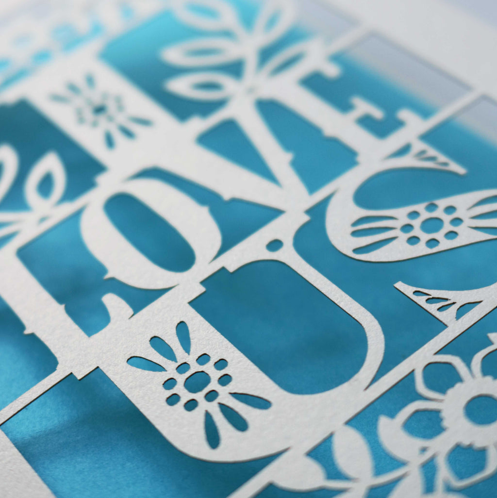 Detail of a laser cut Valentines Day card that says "I love us"