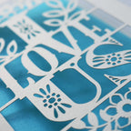 Detail of a laser cut Valentines Day card that says "I love us"