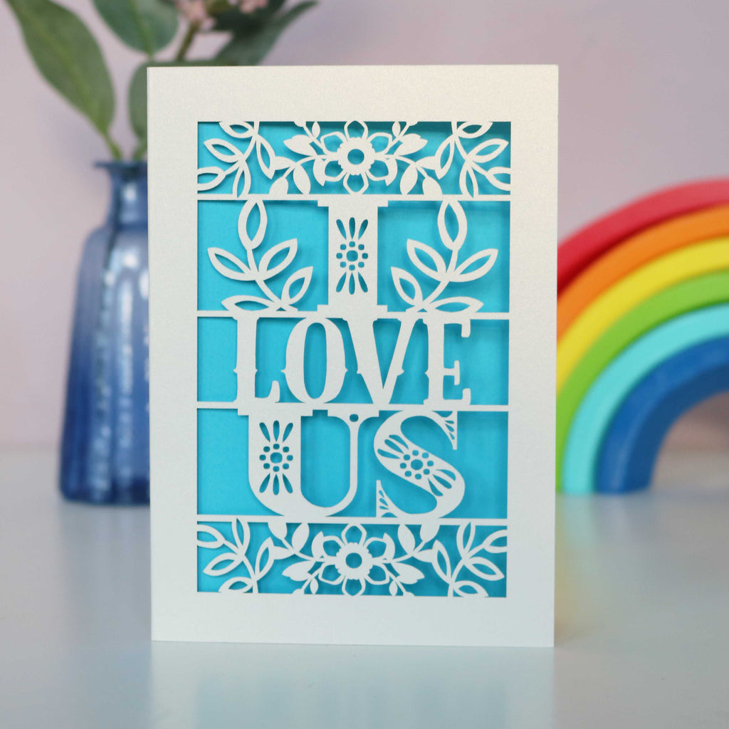 A papercut love Valentine's card with the words 'I LOVE US' cut out.