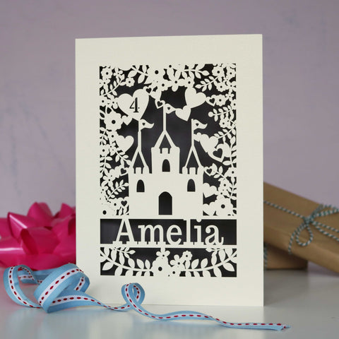 A papercut birthday card with a castle and flower border. The card is personalised and has a name and age. This card shows a grey paper insert. - A5 / Urban Grey