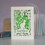 Fresh bright green and cream laser cutout card showing a cat and a balloon. Personalise with their name and age.