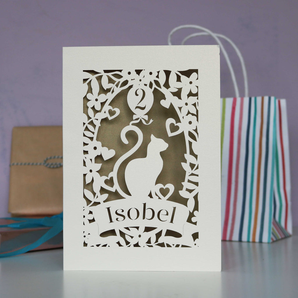 Gold and cream birthday card showing a cat with a balloon. Laser cut and personalised.
