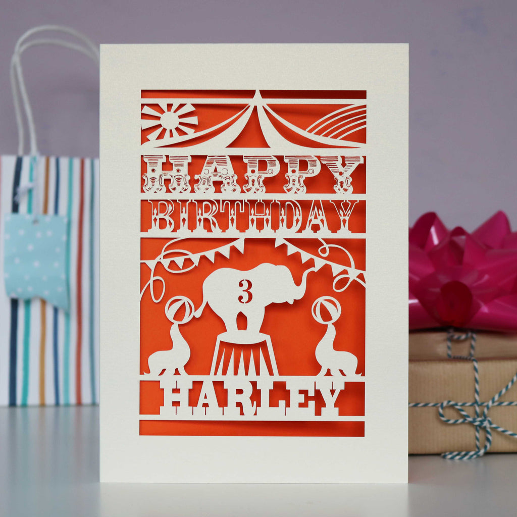 Circus themed kids birthday card showing an elephant under the Big Top. Personalised with name and age and laser cut from cream card with an orange insert paper.