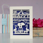 Children's circus theme personalised birthday card. Shows an elephant, seals and bunting under the Big Top. Personalised with a name and age and laser cut from cream card with a dark blue insert paper.