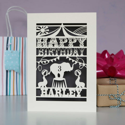 Personalised birthday card lasercut from cream card with an urban grey background. Shows an elephant at the circus with seals and bunting. Personalised with age and name. - A6 (small) / Urban Grey