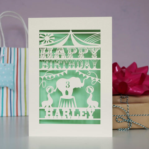 Personalised laser cut birthday card with a circus theme. Personalised with age and name on a cream card with pale green insert paper. - A6 (small) / Light Green