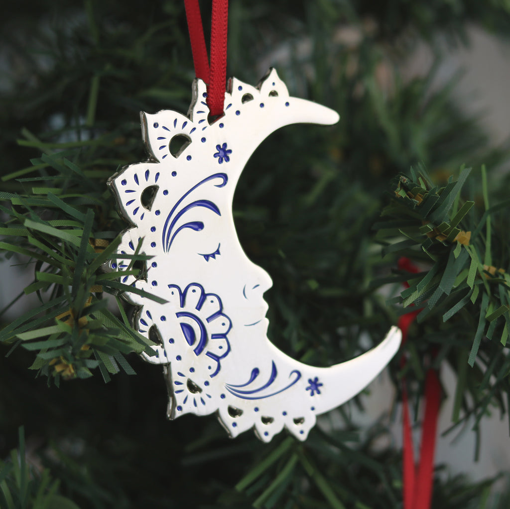 A silver and blue crescent moon Christmas tree ornament