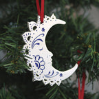 A silver and blue crescent moon Christmas tree ornament