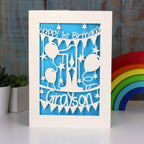 Personalised first birthday paper cut card, cream and peacock blue. Card is laser cut and reads Happy Birthday with a name underneath.