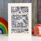 A cream and silver birthday card, personalised and laser cut. Card shows a carousel horse, flowers and stars