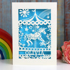 A super girly birthday card with a carousel unicorn and name and age. Laser cut card in cream with a blue paper insert.