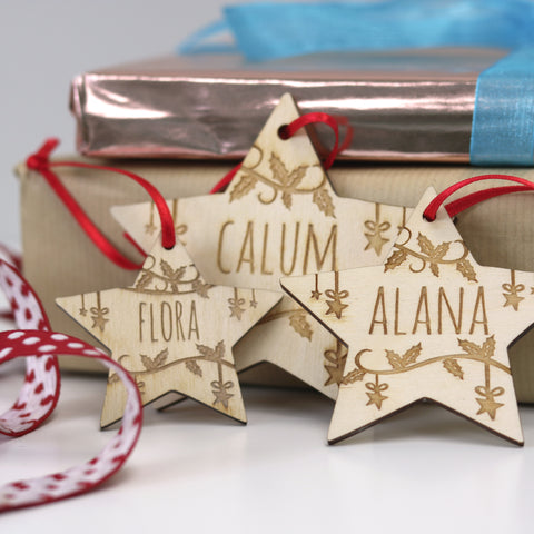 Three different sized star shaped personalised Christmas decorations. - 